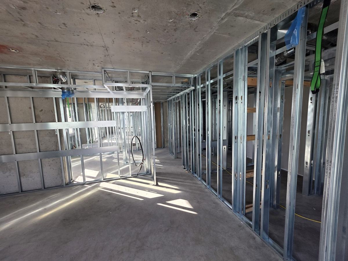 Rows of steel stud partitions framed in a sunlit commercial floor