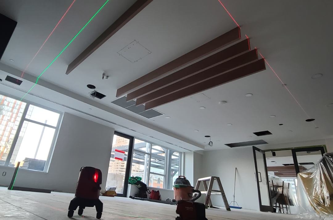 Wood slat feature ceiling being set out with laser lines