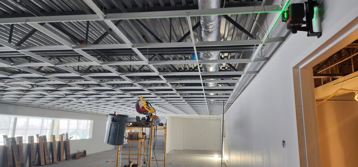 T-bar ceiling grid being installed with a green laser level line